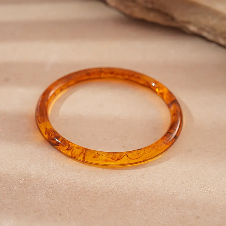 ranslucent amber round dome resin bangle with marbled swirls