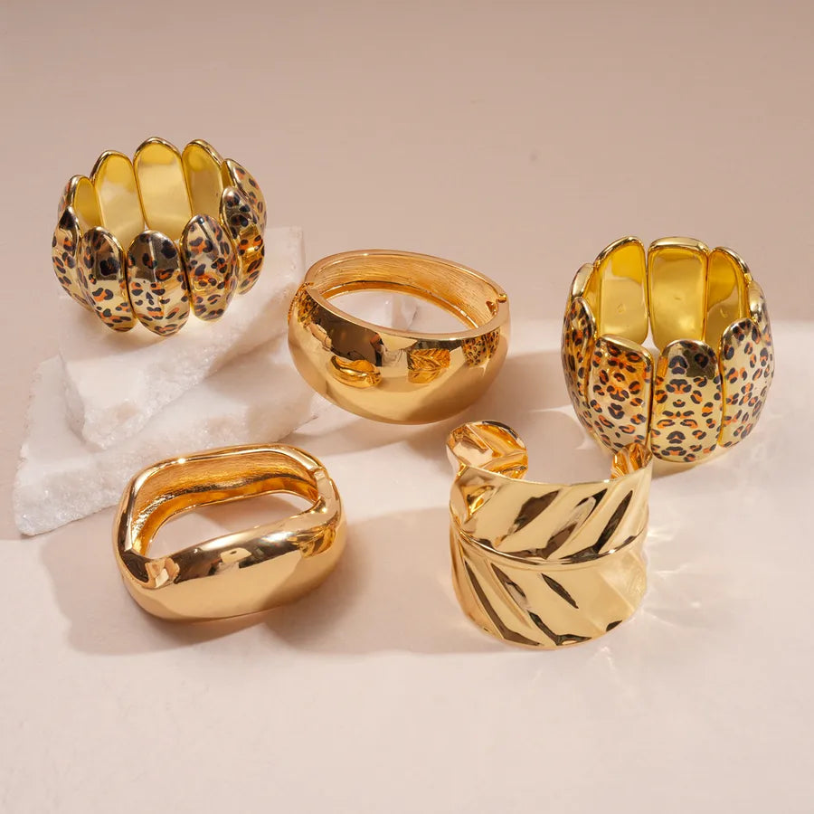 Gold & ivory leopard print segment bangle — wide statement bracelet on model