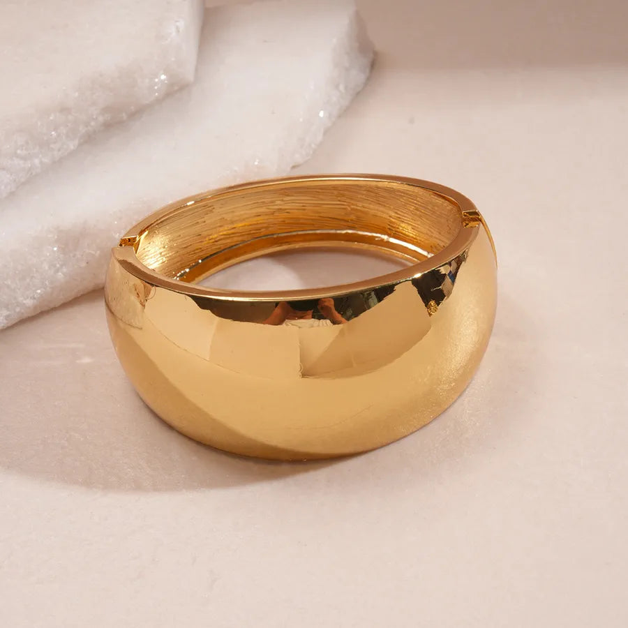 Leopard enamel oval stretch bangle with gold-tone edges stacked on wrist