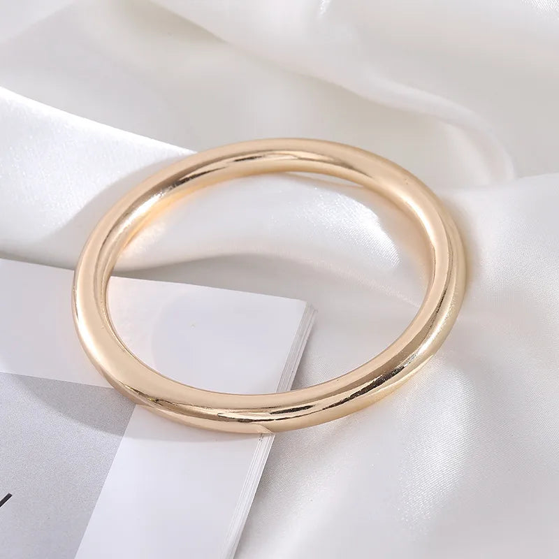 Two polished gold-tone bangles meet a blush resin bangle dotted with mini gold studs. Lightweight, slip-on and made for layering — wear one, double up or stack all three for instant shine.