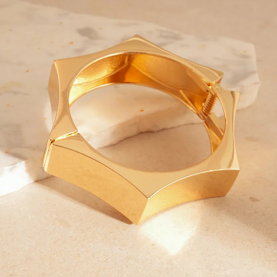 Black resin bangle with gold star studs, statement width