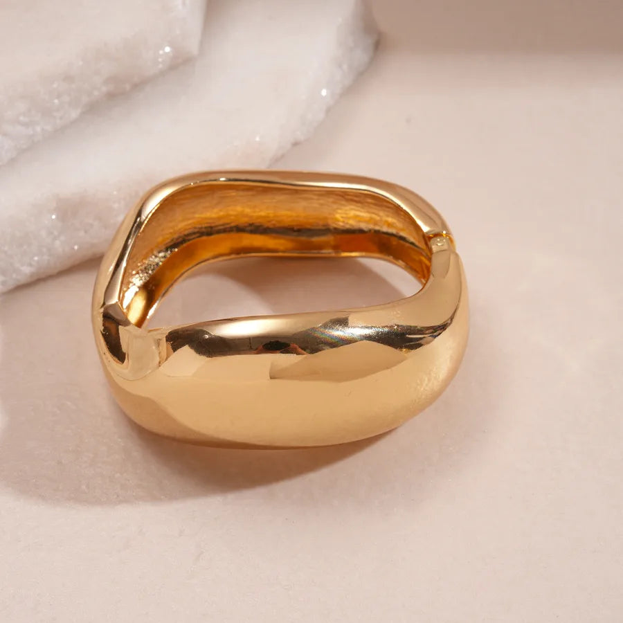 Leopard enamel oval stretch bangle with gold-tone edges stacked on wrist