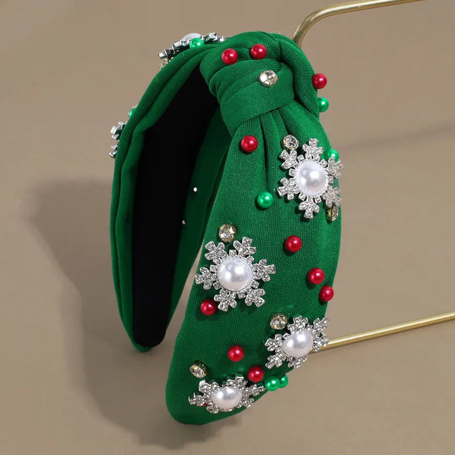 Pearl and rhinestone embellished Christmas headbands in black, red, green, and white — festive holiday hair accessories from The Layers.
