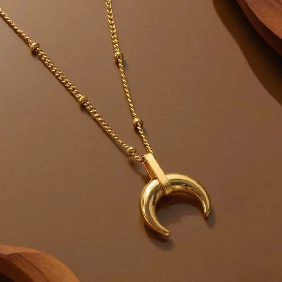 Gold-plated layered necklace with crescent moon pendant on beaded chain — minimalist celestial jewelry from The Layers.