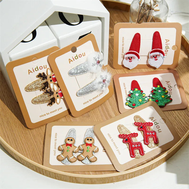 Festive Christmas-themed glitter hair clips featuring Santa, reindeer, Christmas trees, and gingerbread designs — perfect holiday accessories from The Layers.