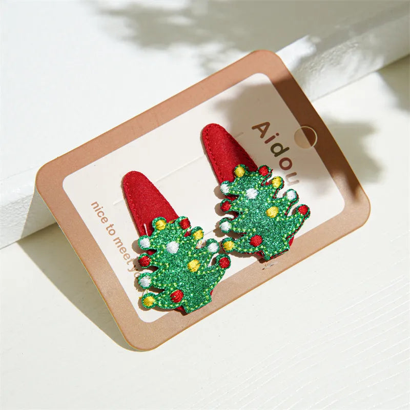 Festive Christmas-themed glitter hair clips featuring Santa, reindeer, Christmas trees, and gingerbread designs — perfect holiday accessories from The Layers.