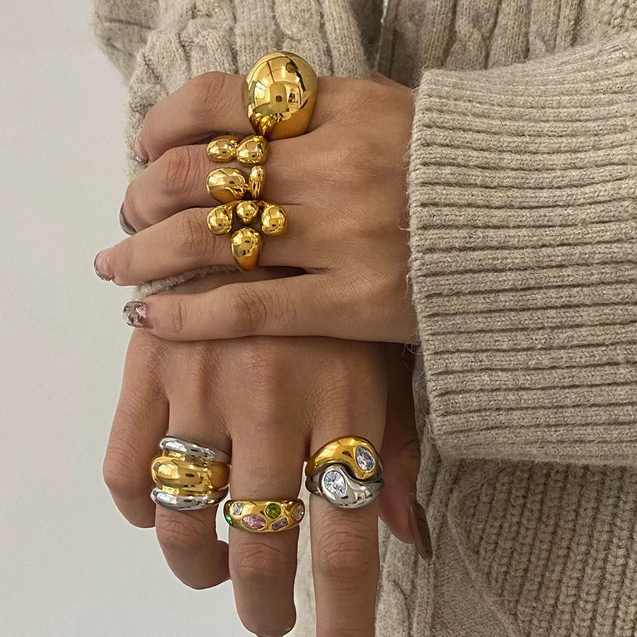 Gold and silver chunky sculptural rings stacked on hands, featuring metallic finish from The Layers jewellery collection.