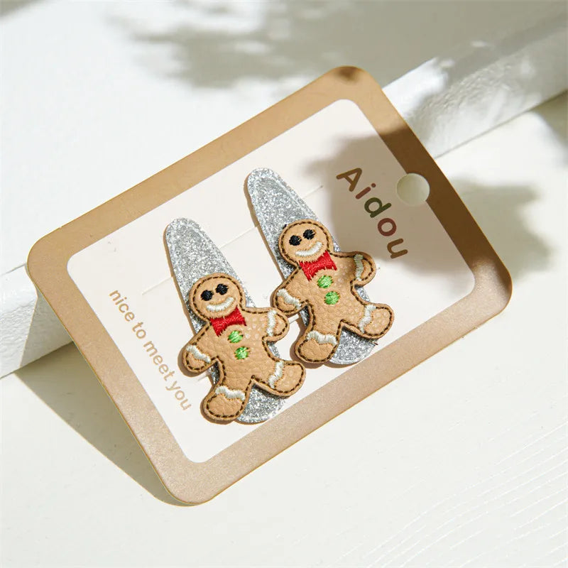 Festive Christmas-themed glitter hair clips featuring Santa, reindeer, Christmas trees, and gingerbread designs — perfect holiday accessories from The Layers.