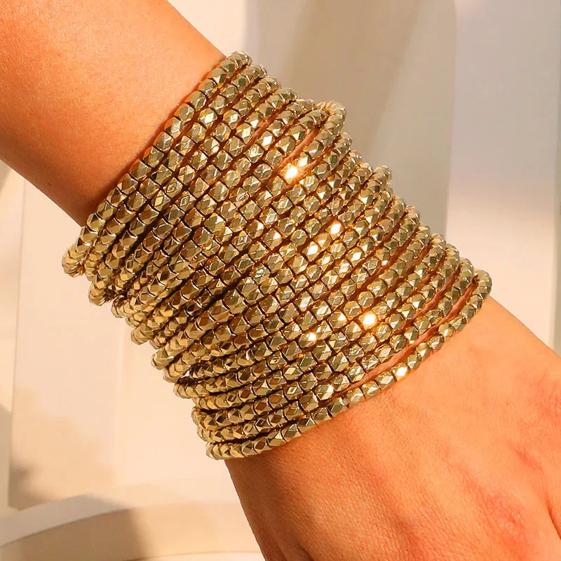 GlowStack gold bangle set – metallic beaded stacking bangles layered on wrist – Layers Store UK