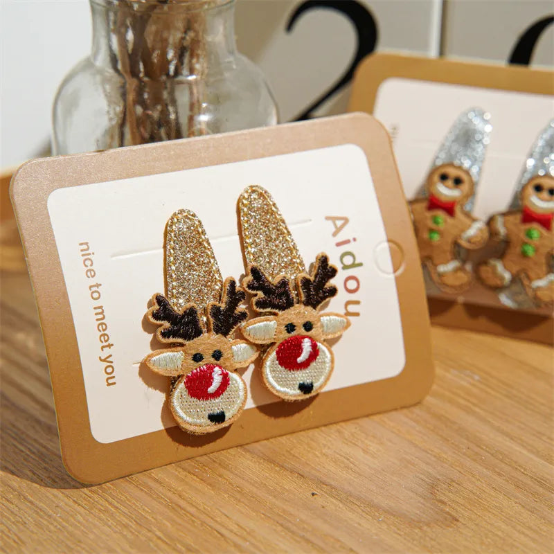 Festive Christmas-themed glitter hair clips featuring Santa, reindeer, Christmas trees, and gingerbread designs — perfect holiday accessories from The Layers.