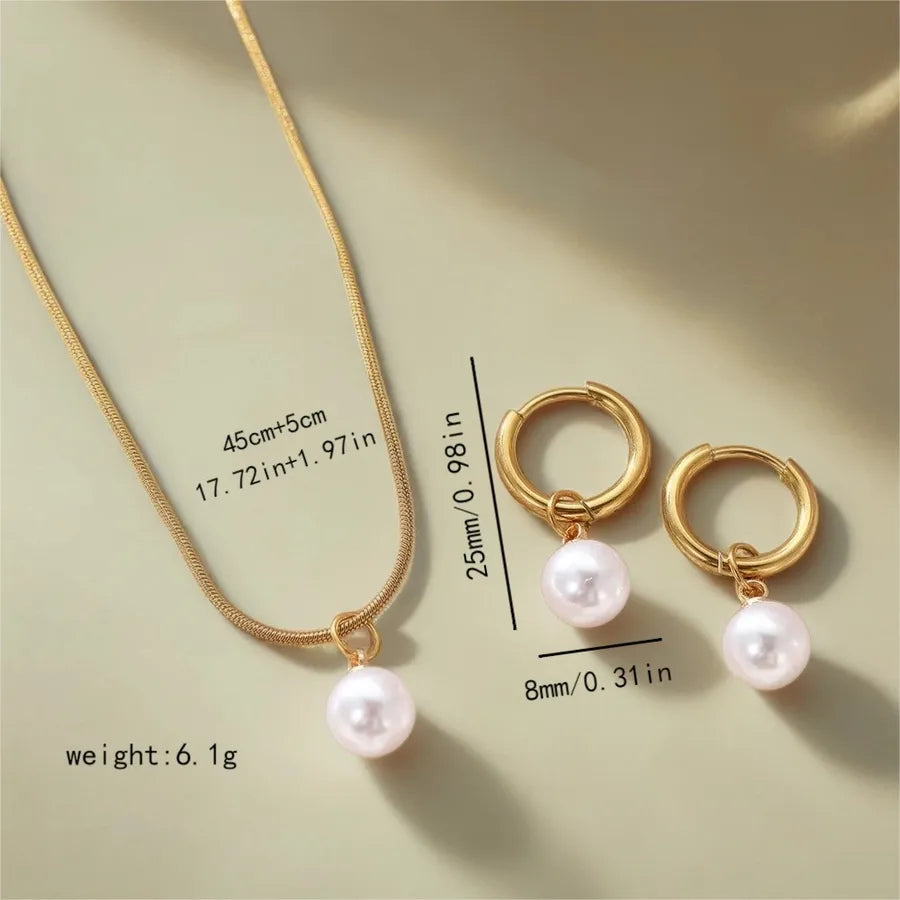 Minimal gold-plated necklace and earrings set featuring round white pearls — modern elegant jewelry from The Layers.