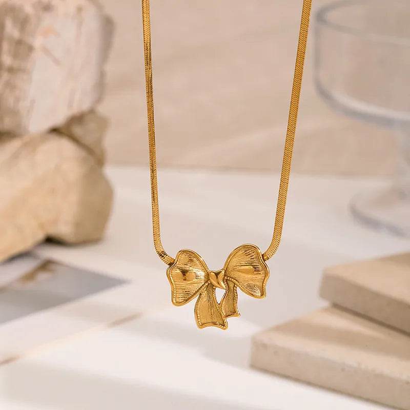 Set of gold-plated charm necklaces featuring moon, bow, gemstone, and enamel fish pendants — elegant handcrafted jewelry from The Layers.