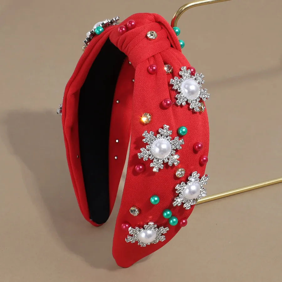 Pearl and rhinestone embellished Christmas headbands in black, red, green, and white — festive holiday hair accessories from The Layers.