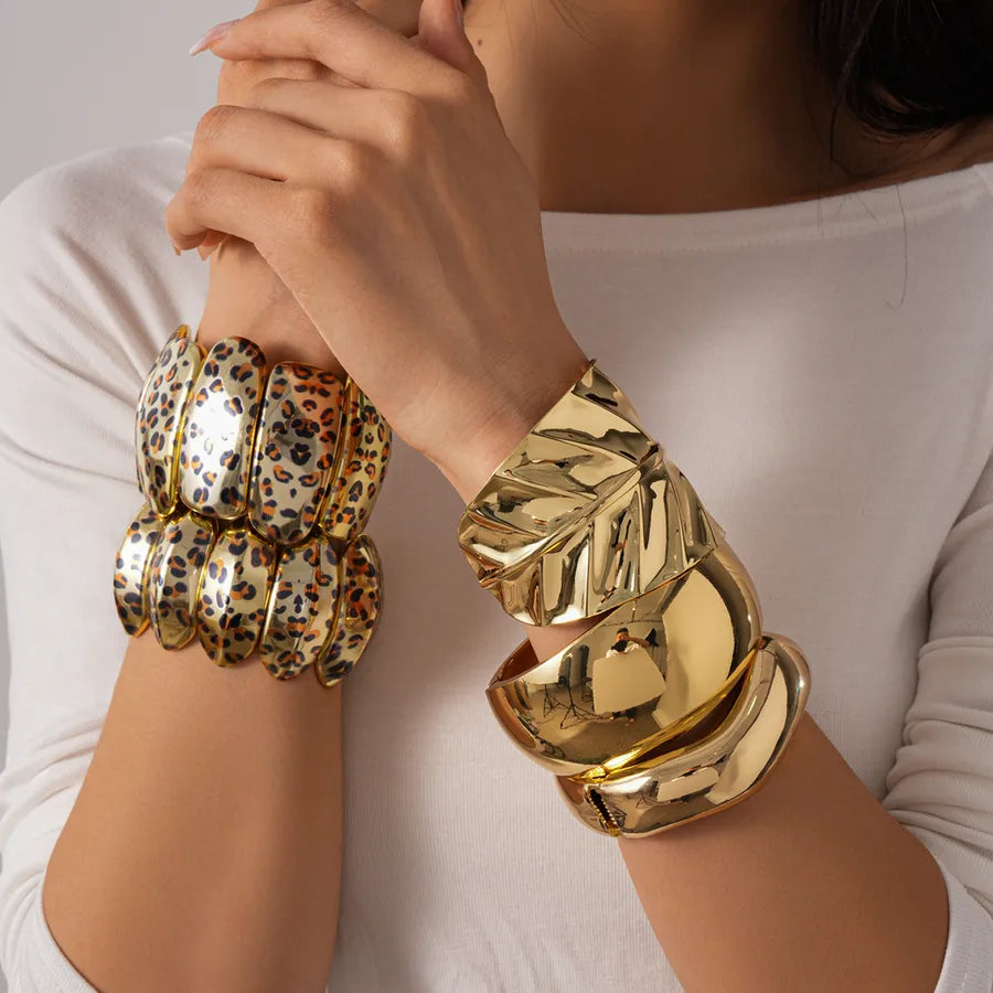 Gold & ivory leopard print segment bangle — wide statement bracelet on model